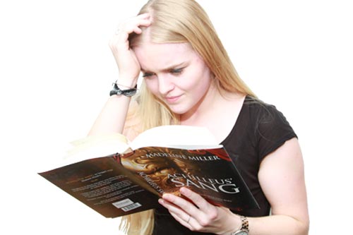 En ung pige har hovedpine og problemer med at læse sin bog